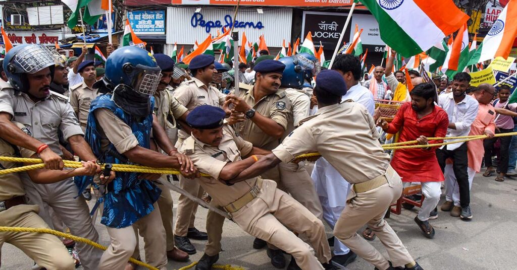राजभवन मार्च के दौरान प्रदर्शनकारियों को रोकती पुलिस