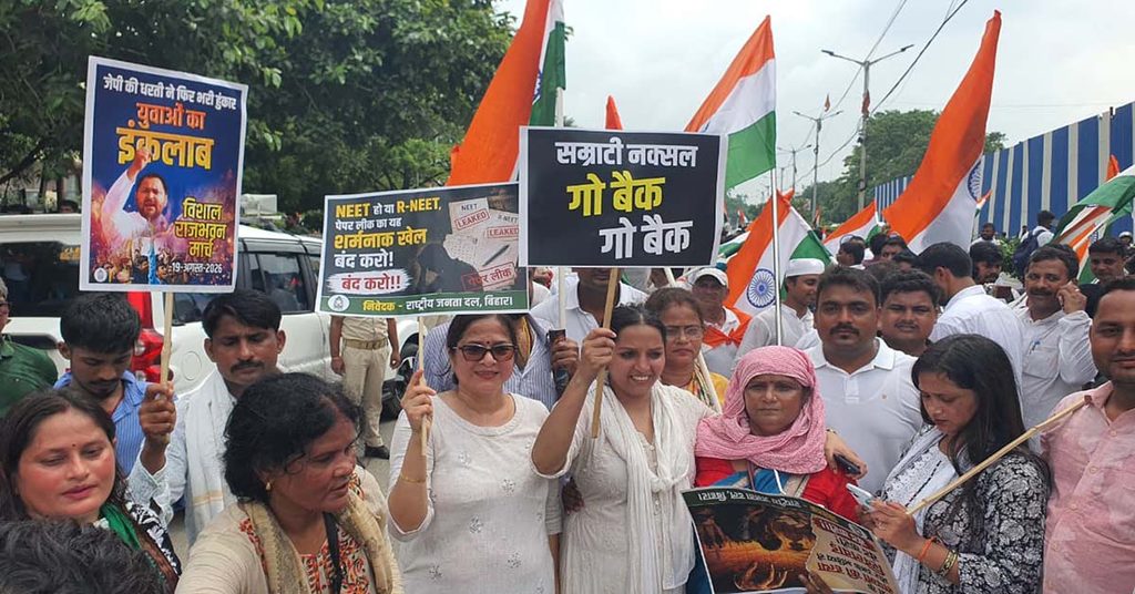 राजभवन मार्च में विभिन्न नारों वाली तख्तियां लिए प्रदर्शनकारी